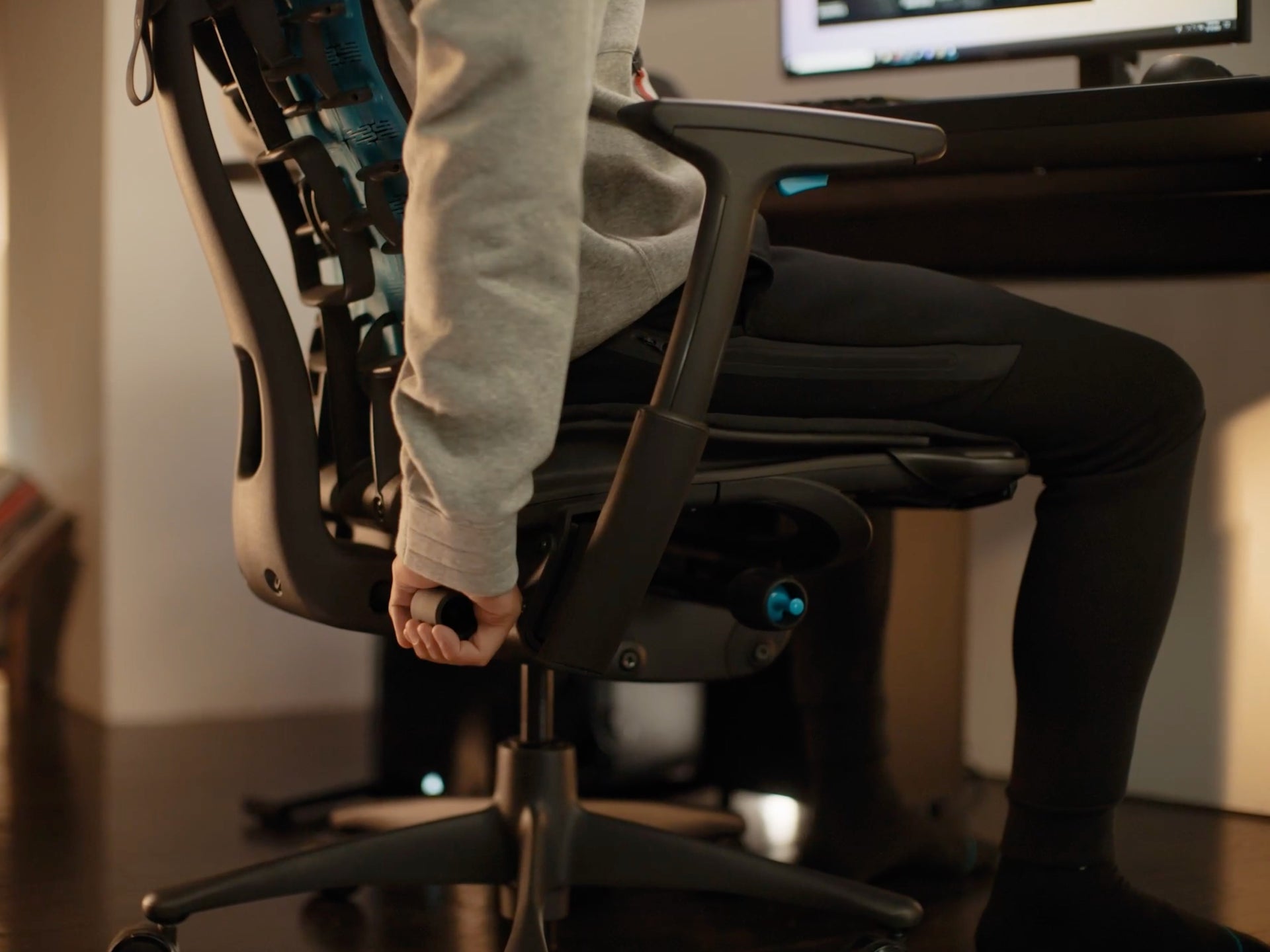 特写视频：一个人的手正在调整黑色Embody电竞椅上的BackFit。